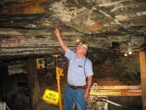 Veteran miner points out a coal seam.
