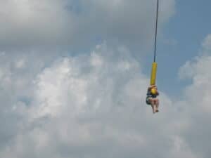 Dangling on the end of a bungee cord.