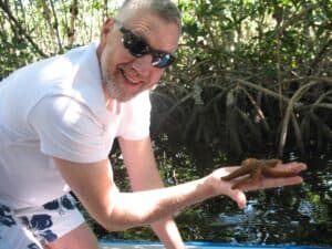 Malcolm Logan with a starfish in the mangrove swamp in Key West