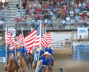 Cowgirls carry flags at the rodeo in Cody, Wyoming