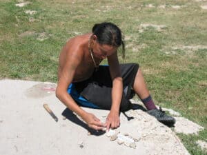 Young Sioux man cleaning a rattlesnake skin