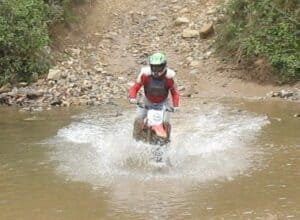 Randy Gray blasts through a creek on his dirt bike at Carolina Adventure World