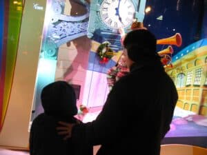 A father shares a tender moment with his son before Macy's Christmas windows in Chicago