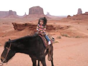 Navajo child riding a horse at Monument Valley